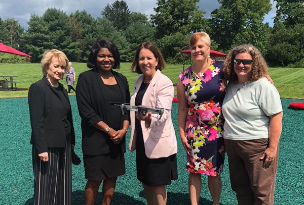 group of staff holding a drone